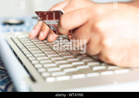male person using a credit card for internet financial transactions. E-commerce and online shopping. Stock Photo