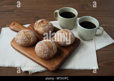 french rye bread with cups of coffee isolated on wooden table Stock Photo