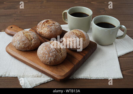 french rye bread with cups of coffee isolated on wooden table Stock Photo
