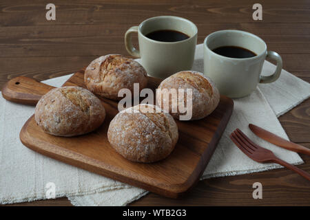 french rye bread with cups of coffee isolated on wooden table Stock Photo