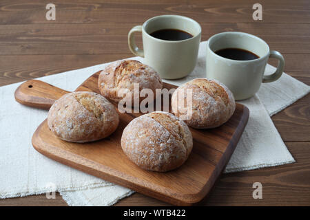 french rye bread with cups of coffee isolated on wooden table Stock Photo