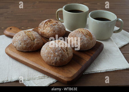 french rye bread with cups of coffee isolated on wooden table Stock Photo