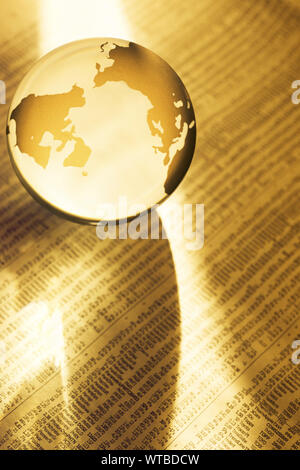 Globe sitting on page of Stock Market listings Stock Photo