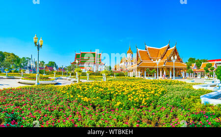 The beautiful flower beds in small Royal Pavilion Mahajetsadabadin park with Wat Ratchanatdaram on the background, Bangkok, Thailand Stock Photo