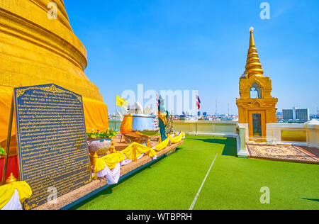 BANGKOK, THAILAND - APRIL 24, 2019: The courtyard on the top of Wat Saket temple with main golden Chedi and small ones with carpets for pray, on April Stock Photo