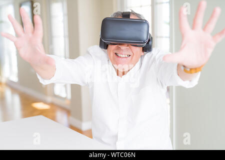 Man wearing virtual reality glasses smiling looking very happy and excited Stock Photo