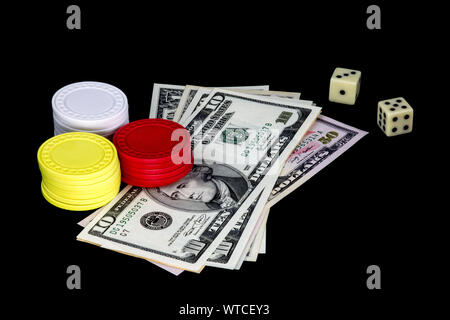 Gambling chips money and dice isolated against a black background Stock Photo
