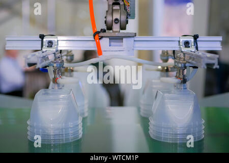 Stack of food containers on conveyor belt of plastic injection molding machine Stock Photo