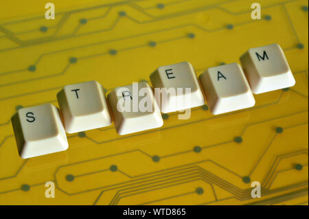 Keyboard keys form the word STREAM on yellow electric circuit in the background. Stock Photo