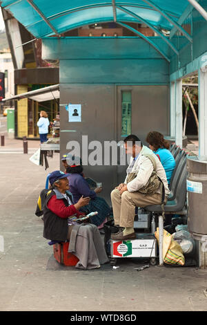 AMBATO, ECUADOR - JUNE 23, 2014: Unidentified female shoeblack talking to a customer in Cevallos Park in the city center on June 23, 2014 in Ambato Stock Photo