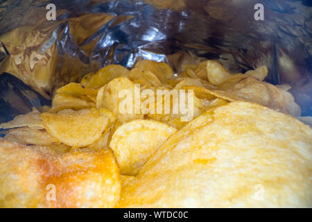 Inside the potato chips bag. Opened pack of original taste delicious potato crisps. Fast food and unhealthy eating concept Stock Photo