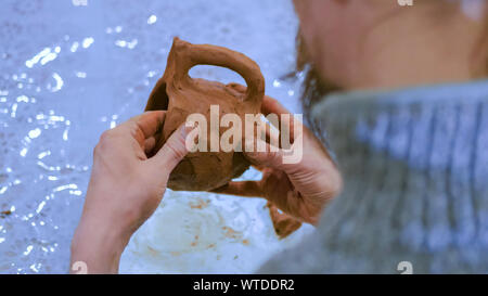 Professional male potter making mug in pottery workshop Stock Photo