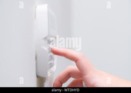 Woman hand entering alarm system password of an apartment, house of business office. Surveillance and protection console against rubbery and thief Stock Photo