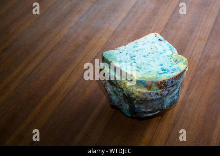 Loaf of rotten, moldy sliced bread on wooden table, space for text Stock Photo