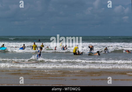 Surfers having a lesson enjoying  the surf at Saunton Sands, near Croyde, North Devon, England, UK Stock Photo