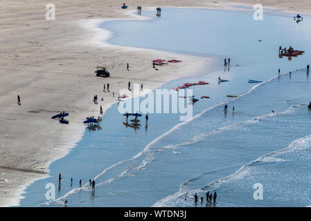 Surfers take to the surf at Saunton Sands, near Croyde, North Devon, England UK Stock Photo