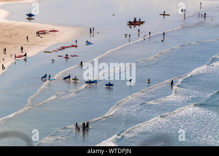 Surfers take to the surf at Saunton Sands, near Croyde, North Devon, England UK Stock Photo