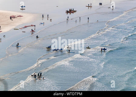 Surfers take to the surf at Saunton Sands, near Croyde, North Devon, England UK Stock Photo