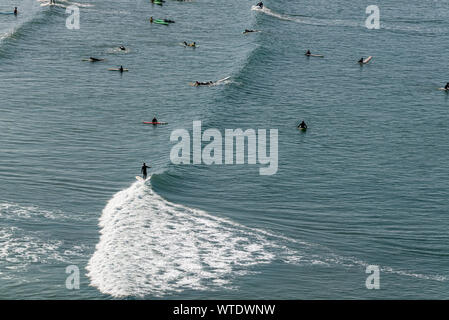 Surfers take to the surf at Saunton Sands, near Croyde, North Devon, England UK Stock Photo