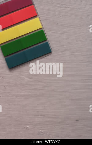 Colored bookmarks lie diagonally on the table. Stripe stickers. Flat lay. Red, yellow, green, blue. Copy space. Stock Photo