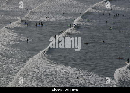 Surfers take to the surf at Saunton Sands, near Croyde, North Devon, England UK Stock Photo