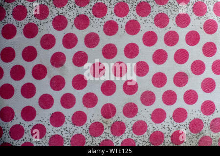 The texture of the old white fabric with red polka dots and black dots on a white background. A lot of red circles. Stock Photo