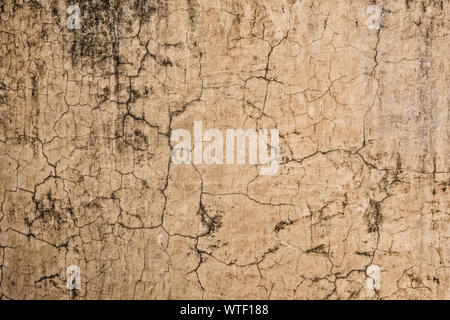 an image of a cracked and weathered plaster coating on an old wall. Stock Photo