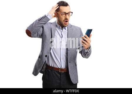 Shocked young man holding his head and looking at a mobile phone isolated on white background Stock Photo