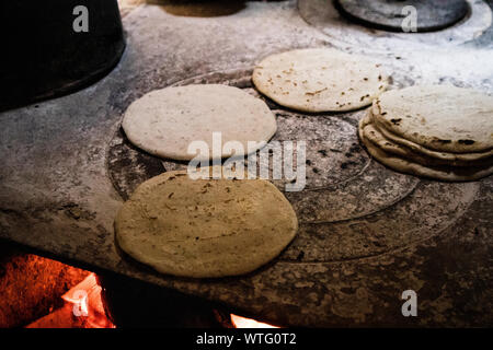 Nutritious handmade corn tortilla cooked on a metal griddle on a gas stove  in a Guatemalan home Stock Photo - Alamy