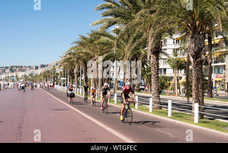 A group of cyclists riding along the promenade in Nice, France, Europe Stock Photo