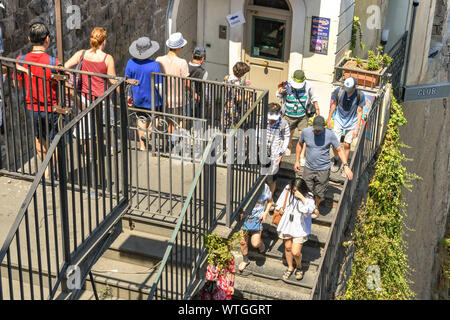 SORRENTO, ITALY - AUGUST 2019: People going down one of the many sets of steps in Sorrento. The steps lead from the town's main square to the port Stock Photo