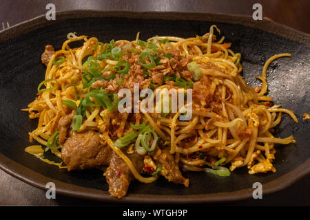 A bami goreng (beef, chicken in noodles), an Indonesian dish, as served in a Munich, Bavaria, Germany Asian food restaurant. Stock Photo