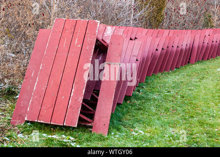 MISSISSAUGA, CANADA - NOVEMBER 30, 2013: Red picnic tables are stacked on edge and secured for winter storage in Memorial Park, near Lake Ontario. Stock Photo