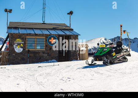 PYRENEES, ANDORRA - FEBRUARY 13, 2019: Rescue service station in a ski resort. Sunny frosty day, snowmobile in the foreground Stock Photo
