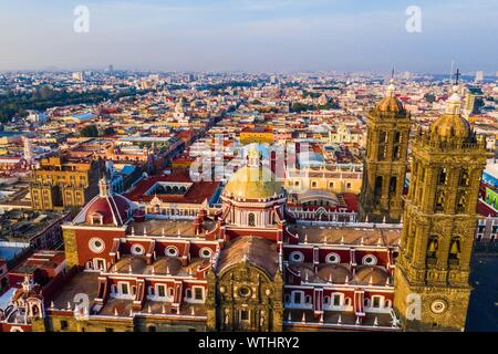 Puebla city pass at sunrise and aerial view of the Basilica or Cathedral of Our Lady of the Immaculate Conception, is the episcopal seat of the archdiocese of the historic and zocalo center of Puebla, Mexico. They have Mexican traditions: gastronomic, colonial architecture and ceramics. Painted talavera tiles adorn ancient buildings. The cathedral of Puebla, in Renaissance style, has a high-rise bell tower overlooking the Zocalo, the central square or zocalo. I enter historical. Architecture is a UNESCO World Heritage Site. Attractions: Cathedral, Temple of Our Lady of Concord, Former Carolino Stock Photo