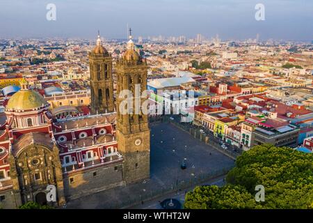 Puebla city pass at sunrise and aerial view of the Basilica or Cathedral of Our Lady of the Immaculate Conception, is the episcopal seat of the archdiocese of the historic and zocalo center of Puebla, Mexico. They have Mexican traditions: gastronomic, colonial architecture and ceramics. Painted talavera tiles adorn ancient buildings. The cathedral of Puebla, in Renaissance style, has a high-rise bell tower overlooking the Zocalo, the central square or zocalo. I enter historical. Architecture is a UNESCO World Heritage Site. Attractions: Cathedral, Temple of Our Lady of Concord, Former Carolino Stock Photo