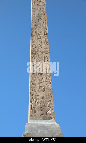 Old Egyptian Obelisk with hieroglyphs and blue sky on background Stock Photo