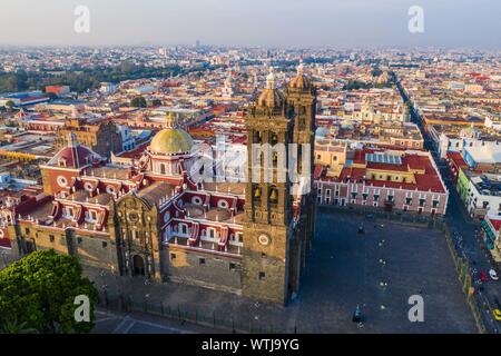 Puebla city pass at sunrise and aerial view of the Basilica or Cathedral of Our Lady of the Immaculate Conception, is the episcopal seat of the archdiocese of the historic and zocalo center of Puebla, Mexico. They have Mexican traditions: gastronomic, colonial architecture and ceramics. Painted talavera tiles adorn ancient buildings. The cathedral of Puebla, in Renaissance style, has a high-rise bell tower overlooking the Zocalo, the central square or zocalo. I enter historical. Architecture is a UNESCO World Heritage Site. Attractions: Cathedral, Temple of Our Lady of Concord, Former Carolino Stock Photo