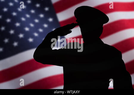 Silhouette of soldier saluting in front of US flag Stock Photo