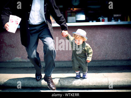 Father and son holding hands to cross the road Stock Photo