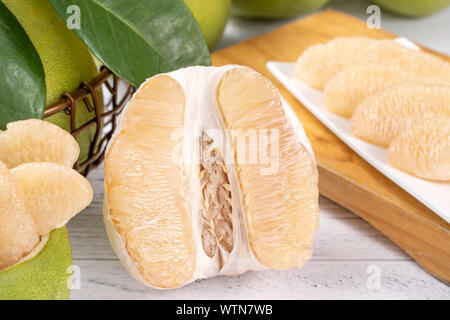 Fresh peeled pomelo, grapefruit, shaddock on bright wooden table background. Seasonal fruit for Mid-Autumn Festival, close up, copy space. Stock Photo
