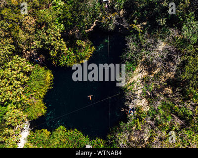 From above female with outstretched arms enjoying bath in clean Cenote Stock Photo