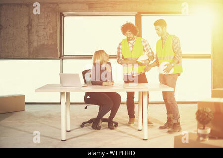 young team of business people in group, architect and engineer on construction site checking documents and business workflow using laptop computer wit Stock Photo