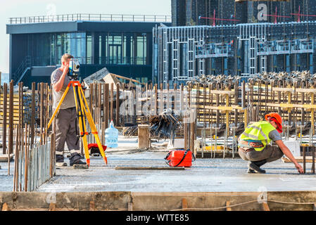 Surveyor engineer working with theodolite at a construction site. Stock Photo