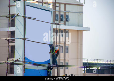 Workers on the scaffold are installing billboards. Stock Photo