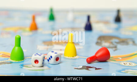 Board games for the home. Colored plastic chips and dice on the background of board games . Selective focus Stock Photo