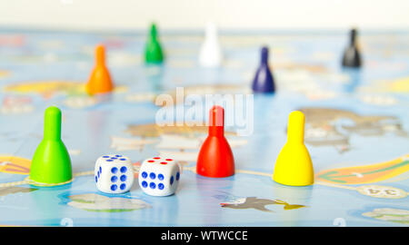 Board games for the home. Colored plastic chips and dice on the background of board games . Selective focus Stock Photo