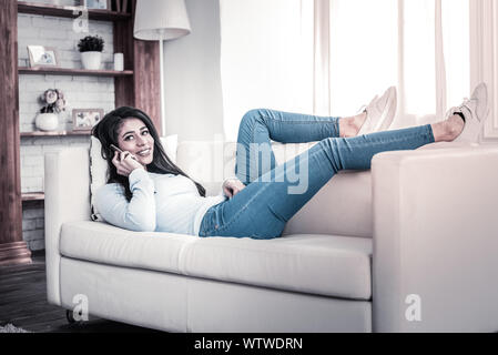 Beautiful long-haired girl having conversation on her phone Stock Photo