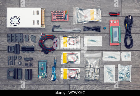 Flat lay of electronic and mechanical parts and components of DIY device on wooden surface