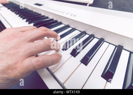 Man playing on piano close-up wide shot toned Stock Photo